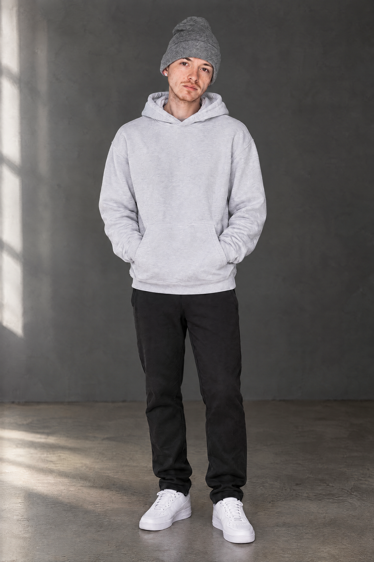 Creative full-length portrait of Chase Davis in a gray hoodie and beanie.